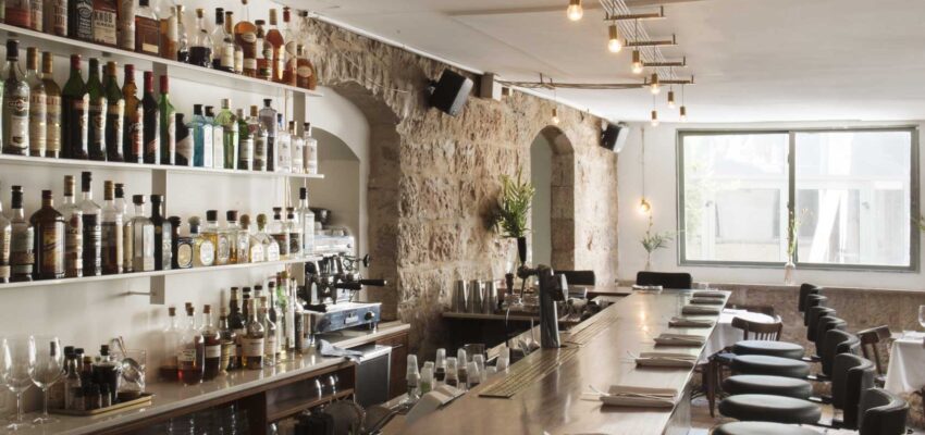 **Alternative Balise :**
*Bar rustique, murs en pierre, comptoir en bois, luminaires suspendus.*