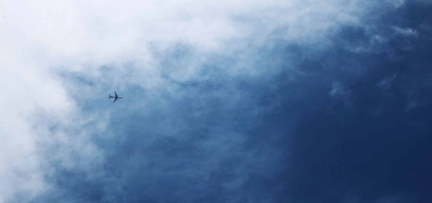 Location jet privé : Avion dans ciel nuageux.