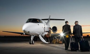 location jet privé: Hommes avec valises marchent vers un jet.