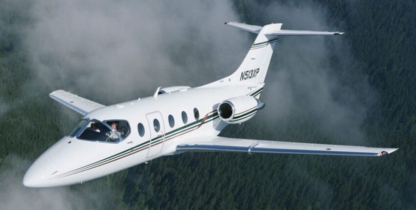 **Texte alternatif:**  
Location de jet privé, BEECHJET 400 survole une forêt.
