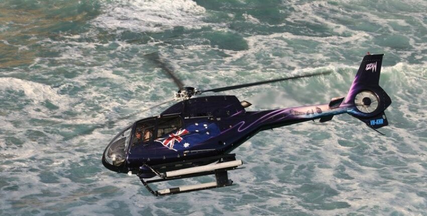 Hélicoptère H120 en vol au-dessus de la mer