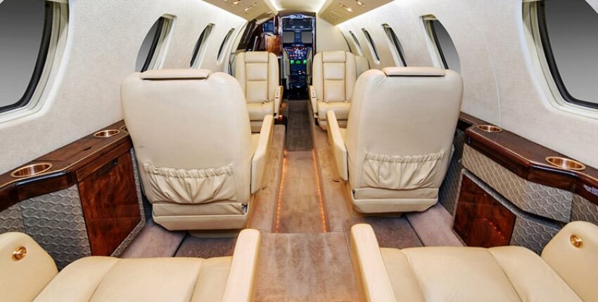 **location de jet privé** Luxueux intérieur beige avec accents bois.