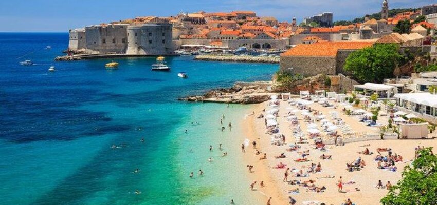 Croatie jet privé : plage ensoleillée avec fort médiéval.